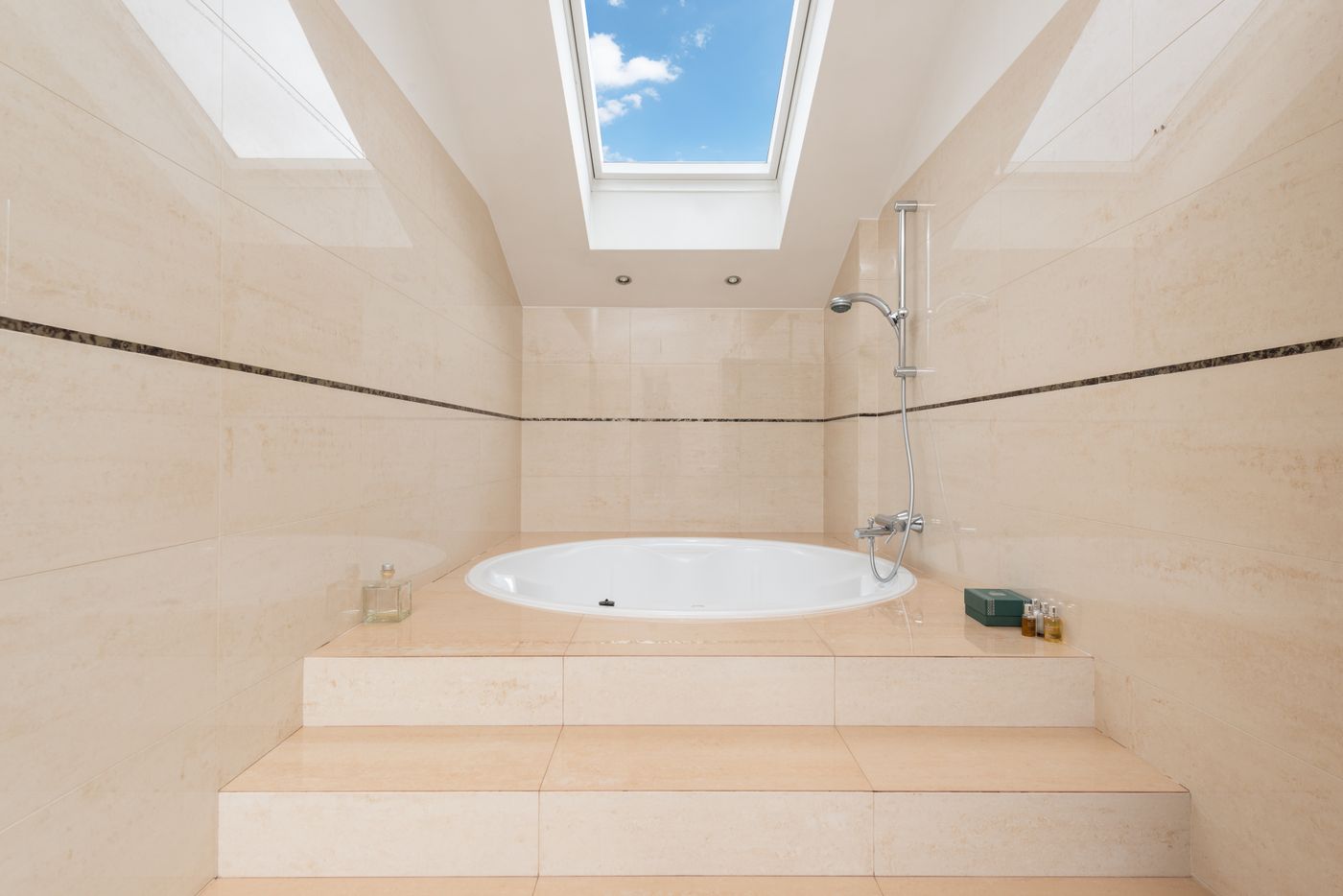 Soft cream bathroom bathed in natural light from a skylight